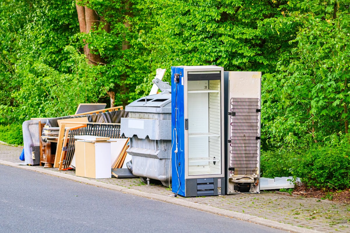 Discarded household appliances and furniture piled up for collection on the roadside