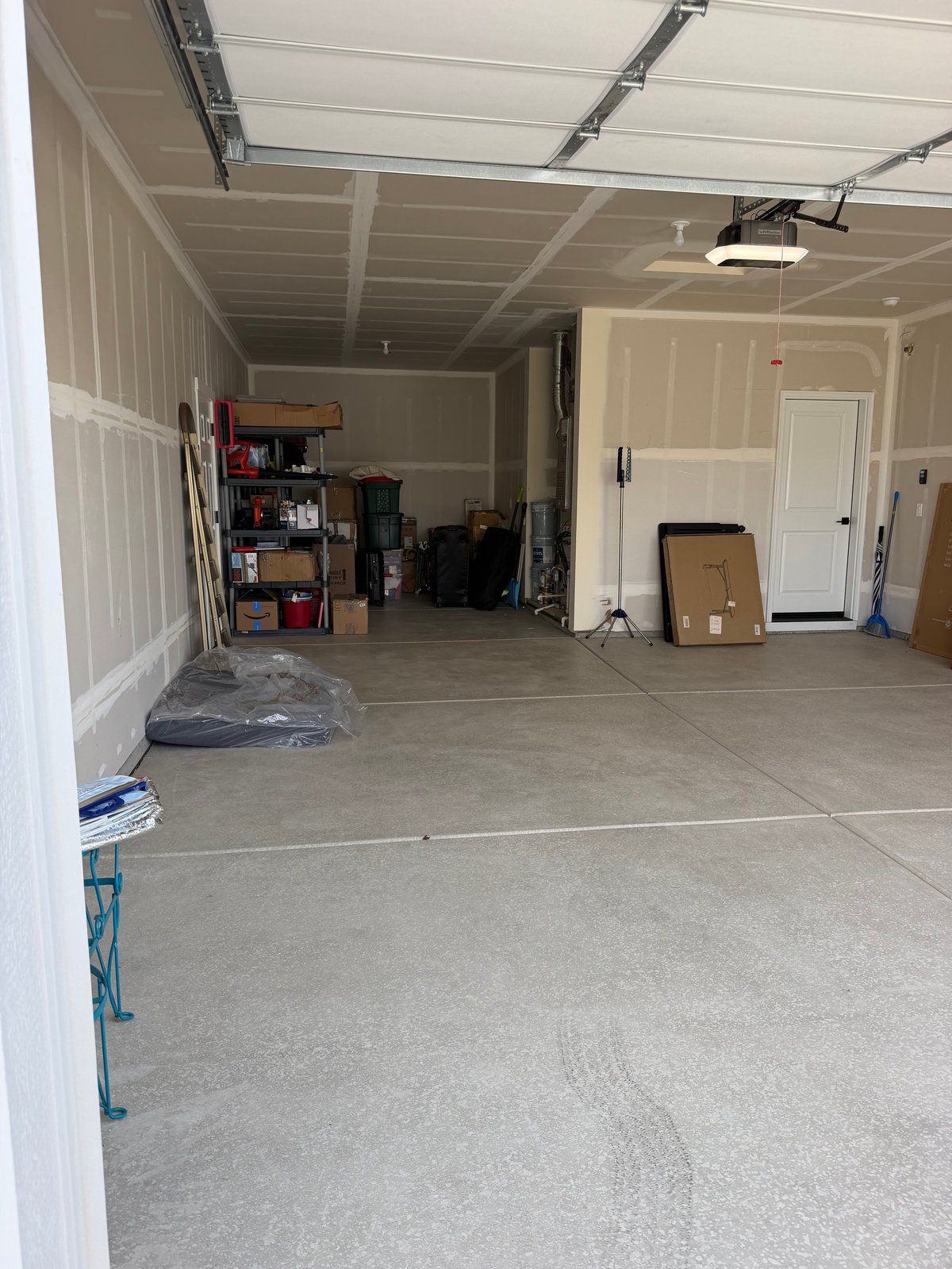 Empty garage interior with concrete floor and storage shelving along the walls